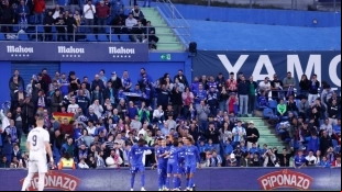 The Getafe players celebrate a goal against Real Madrid.
